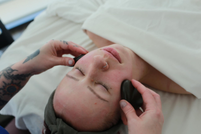 Marissa performing a facial massage with hot stones